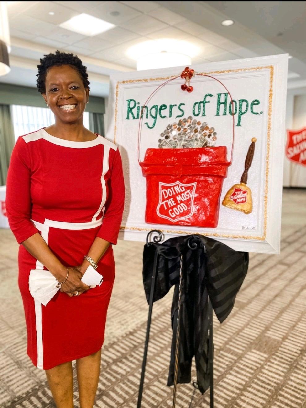 Brenda Caldwell beside her Salvation Army Ringers of Hope artwork.